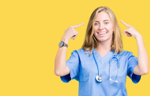 Hermosa Joven Doctora Vistiendo Uniforme Médico Sobre Fondo Aislado Sonriendo —  Fotos de Stock