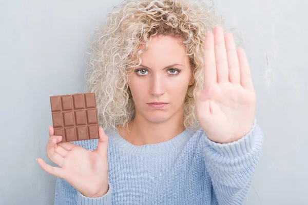 Junge Blonde Frau Über Grunge Graue Wand Essen Schokoladenriegel Mit — Stockfoto