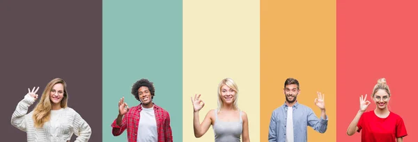一群年轻人在五颜六色的复古孤立的背景微笑正面做确定的标志用手和手指 成功的表达 — 图库照片