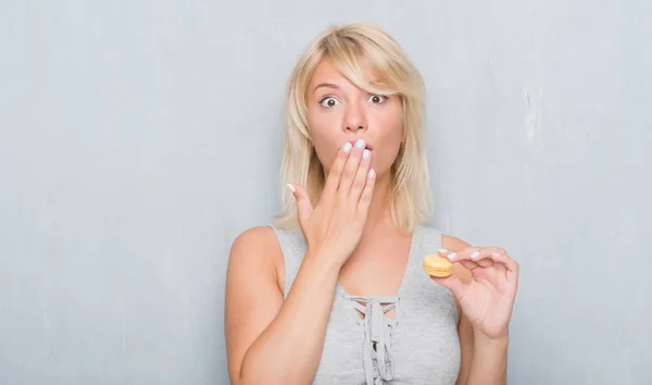 Adult Caucasian Woman Grunge Grey Wall Eating Macaron Cover Mouth — Stock Photo, Image