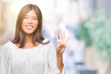 Genç Asyalı kadın gösterilen ve parmakları ile işaret izole arka plan üzerinde dört kendinden emin ve mutlu gülümseyerek iken numara.