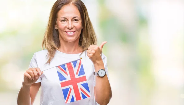 中年西班牙妇女拿着英国的旗帜在孤立的背景高兴与灿烂的微笑做确定的标志 用手指竖起大拇指 优秀的标志 — 图库照片
