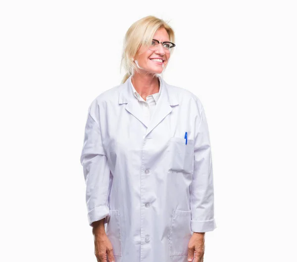 中年金发治疗师妇女穿白色大衣在孤立的背景看一边与微笑的脸上 自然的表达 笑的自信 — 图库照片