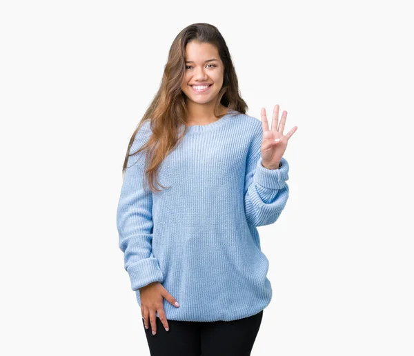 孤立した背景表示と指で上向きに青い冬のセーターを着ている若い美しいブルネットの女性数は自信を持って 幸せな笑みを浮かべている間 — ストック写真