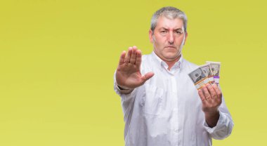 Yakışıklı komuta sizde para demet izole arka plan üzerinde açık eliyle dur işareti ile ciddi ve kendine güvenen ifade, savunma jest yapıyor holding