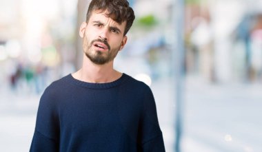 Şüpheci ve alaycı, arayan genç yakışıklı adam şok karşısında izole arka plan üzerine açık ağız ile şaşırttı