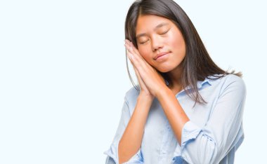 Genç Asyalı iş kadını uyku yorgun hayal ve ile gülümseyen gözleri kapalı iken ellerle birlikte poz izole arka plan üzerinde.