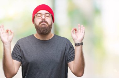 Genç beyaz hipster adam gözlük izole arka plan üzerinde dinlenmek ve gülümseyen gözlerle kapalı parmak jestle meditasyon yapıyor. Yoga kavramı.