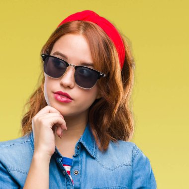 Genç güzel kadın yüzünden izole arka plan çene düşünme hakkında soru, dalgın ifade üzerine el ile güneş gözlüğü takıyor. Düşünceli yüzüyle gülümsüyor. Şüphe kavramı.