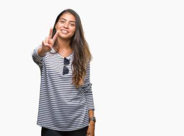 Genç güzel Arap kadın parmaklarını zafer işareti yaparken gösterilen kamera seyir gülümseyen izole arka plan üzerinde güneş gözlüğü takıyor. İki numaralı.