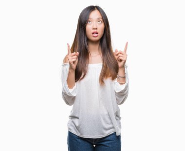 Genç Asyalı kadın izole arka plan üzerinden hayran ve yukarıya bakıp parmakları ile işaret şaşırttı ve silah kaldırdı.