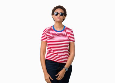 Güzel genç Afro-Amerikan kadın yüzünde ciddi bir ifade ile izole arka plan üzerinde güneş gözlüğü takıyor. Basit ve doğal kameraya bakıyor.