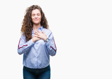 Elgant göz kapalı gözler ile göğüs ellerinde ve yüzünde minnettar jest ile gülümseyen izole arka plan üzerinde giyen güzel esmer kıvırcık saçlı Genç kız. Sağlık kavramı.