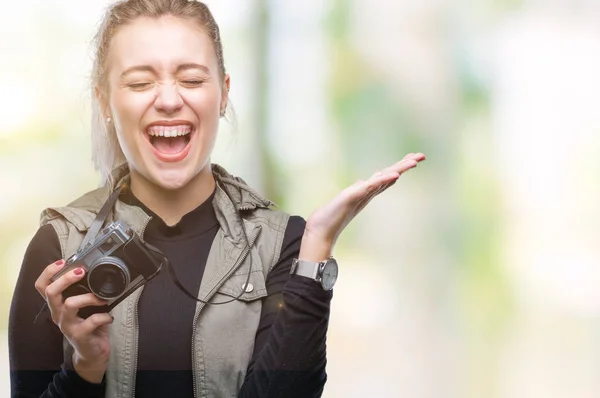 年轻的金发女人拍照使用老式相机在孤立的背景非常高兴和兴奋 优胜者表达庆祝胜利尖叫着大微笑和举手 — 图库照片