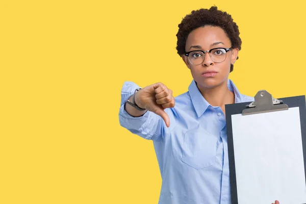 怒った顔 ダウン親指で嫌悪感を示すマイナス記号 拒絶反応の概念と分離された背景にクリップボードを保持している若いアフリカ系アメリカ人ビジネス女性 — ストック写真