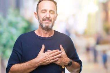 Orta yaş ağarmış komuta sizde ile gülümseyen izole arka plan üzerinde kapalı gözler ve yüzünde minnettar jest ile göğüs üzerinde eller. Sağlık kavramı.