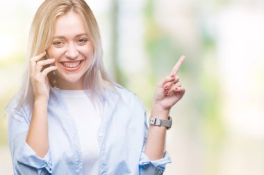 Genç Sarışın kadın üzerinde smarpthone kullanma söz arka plan el ve parmak ile tarafına işaret çok mutlu izole