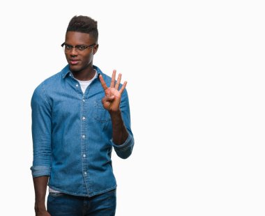 Gösterilen ve parmakları ile işaret izole arka plan üzerinde genç Afro-Amerikan adam kendinden emin ve mutlu gülümseyerek süre dört numara.