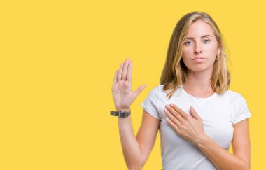 Güzel genç kadın üzerinde rahat beyaz t-shirt giyen izole arka plan göğüs ve bir sadakat sözü yemin yapma avuç, el ile küfür