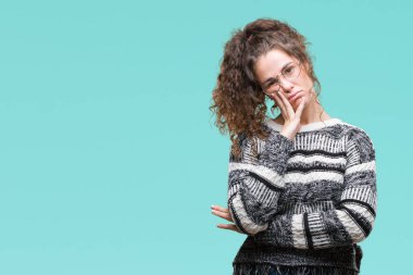 Güzel esmer kıvırcık saçlı Genç kız gözlüklü düşünme izole arka plan bakmaktan yorgun ve sıkılmış çapraz silah depresyon sorunları ile.
