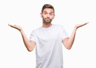 İzole arka plan clueless ve şaşkın bir ifadeyle kollar ve eller kaldırdı genç yakışıklı adam. Şüphe kavramı.