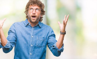 Yakışıklı İspanyol izole arka plan üzerinde kutluyor deli gözlüklü adam model ve silah ile başarı için yükseltilmiş ve açık gözleri heyecanlı çığlık hayrete düşürdü. Kazanan kavramı