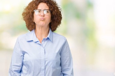 Komik surat ile yanakları şişirme izole arka plan üzerinde gözlük giyen güzel orta ager üst düzey businees kadın. Ağız ile hava, deli ifade şişirilmiş.