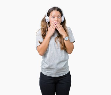 Üzerinden müzik kulaklık giyen genç güzel kadın arka plan ağız hata için elleriyle kapsayan şok izole. Gizli kavramı.