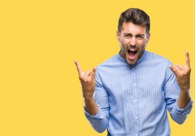 Yakışıklı delikanlı deli ifade rock simge elle yapıyor ile bağırarak izole arka plan üzerinde. Müzik yıldızı. Ağır kavramı.