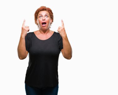 Atrractive üst düzey beyaz Kızıl saçlı kadın izole arka plan üzerinden hayran ve yukarıya bakıp parmakları ile işaret şaşırttı ve silah kaldırdı.