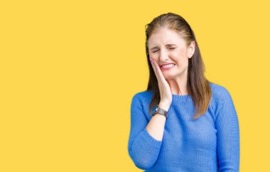 Diş ağrısı veya dişlerde dişlerle ilgili hastalık nedeniyle ağız acı ifadesi ile el ile dokunmak izole arka plan üzerinde kış kazak giyen güzel orta yaş Olgun kadın. Diş hekimi kavramı.