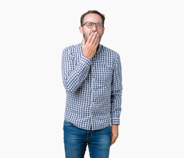 Yakışıklı orta yaş esneme izole arka plan üzerinde gözlüklü zarif üst düzey iş adamı sıkılmış kapsayan ağız el ile yorgun. Restless ve uyku hali.