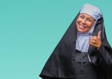 Orta yaş üst düzey Hıristiyan Katolik Rahibe kadın yapıyor gülümseyen izole arka plan üzerinde telefon hareketi ile el ve parmak telefonda konuşuyor gibi. Kavramları iletişim.