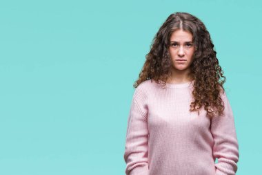 Yüzünde ciddi bir ifade ile izole arka plan üzerinde pembe kış kazak giyen güzel esmer kıvırcık saçlı Genç kız. Basit ve doğal kameraya bakıyor.