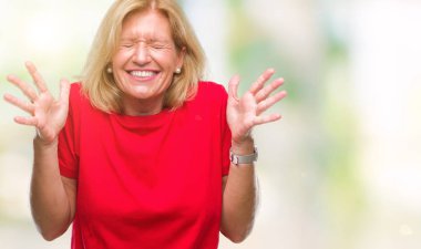 Orta yaş sarışın kadın deli ve silah ile başarı için deli kutluyor izole arka plan üzerinde kaldırdı ve heyecanlı çığlık gözler kapalı. Kazanan kavramı