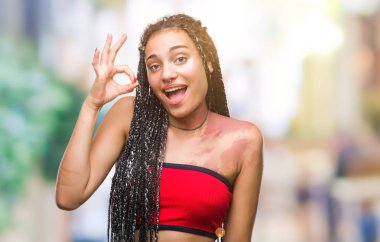 Genç örgülü saç Afrika kökenli Amerikalı pigmentasyon ile Doğum işareti izole arka plan el ve parmaklar ok işaretiyle yapıyor olumlu gülümseyen üzerinde leke. Başarılı ifade.