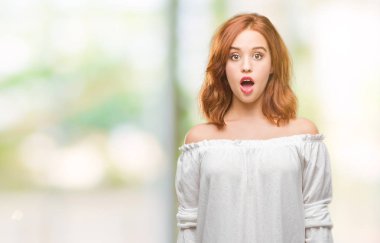 Genç güzel kadın izole arka plan korkuyor ve sürpriz ifade ile şok yüzünden korku ve yüz heyecanlı.