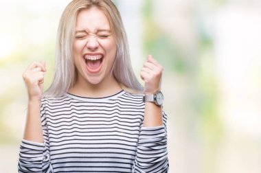 Sarışın genç kadın izole arka kolları olan başarı için heyecan üzerinde zafer kutluyor gülümseyen kaldırdı. Kazanan kavramı.