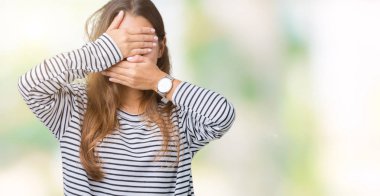 İzole arka plan kaplaması gözler ve ağız el ile üzerinden çizgili süveter giyen genç güzel esmer kadın şaşırttı ve şok. Duygu gizleme