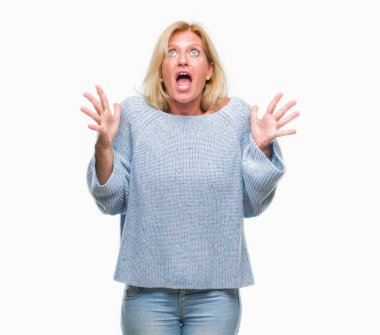 Orta yaş sarışın kadın üzerinde kış kazak giyen arka plan deli izole ve deli bağırarak ve agresif ifade ve silah kaldırdı bağırıyor. Hayal kırıklığı kavramı.