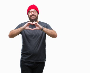 Kalp simgesi ve elleriyle şekil gösterilen aşık gülümseyen izole arka plan üzerinde gözlük takan Genç beyaz hipster adam. Romantik kavramı.
