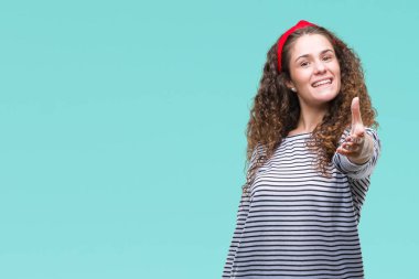 Güzel esmer kıvırcık saçlı Genç kız giyiyor kazak tebrik ve konuksever dost sunan karşılıklı gülümseyen izole arka plan üzerinde çizgili. Başarılı iş.