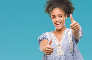 Genç afro Amerikalı kadın el ile pozitif jest yapıyor onaylama izole arka plan üzerinde başparmak gülümseyen ve başarı için mutlu. Kamera, kazanan jest arıyorsunuz.