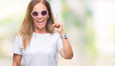 Orta yaş İspanyol kadın başarılı fikirle izole arka plan işaret parmağı üzerinde moda güneş gözlüğü takıyor. Çıktıktan ve mutlu. Bir numara.