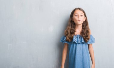 Genç İspanyol çocuğun grunge gri duvar yapım balık yüzüne dudaklı, çılgın ve komik bir jest. Komik ifade.