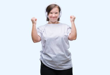 Down sendromlu izole arka plan kutlama üzerinde kulaklık giyen genç yetişkin kadın şaşırttı ve silah ile başarı için yükseltilmiş ve açık gözler hayrete düşürdü. Kazanan kavramı.