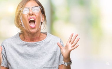 Üzerinde gözlük takan orta yaş İspanyol kadın kıdemli arka plan deli izole ve deli bağırarak ve agresif ifade ve silah kaldırdı bağırıyor. Hayal kırıklığı kavramı.