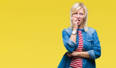 Stresli ve gergin ile izole arka plan üzerinde kot ceket giyen genç güzel sarışın kadın tırnak ısırma dudaklarından eller. Anksiyete sorunu.