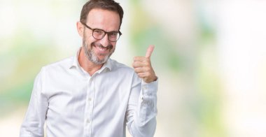 Hareketi el ile mutlu yaşasın yapıyor izole arka plan üzerinde gözlük takan yakışıklı orta yaş zarif üst düzey iş adamı. Başarı gösteren kameraya bakarak ifade onaylama.