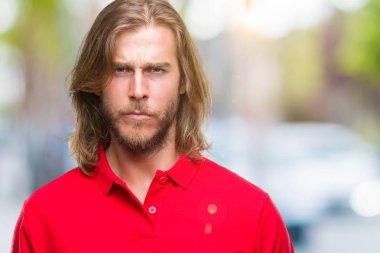 Yakışıklı delikanlı izole arka plan şüpheci ve sinir, papatyanın üzgün sorun nedeniyle uzun saçlı. Negatif kişi.